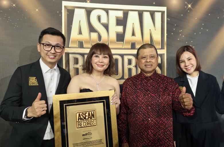 Group of four people posing on a stage with a gold-framed ASEAN Records plaque and a large 'ASEAN RECORDS' sign in the background.