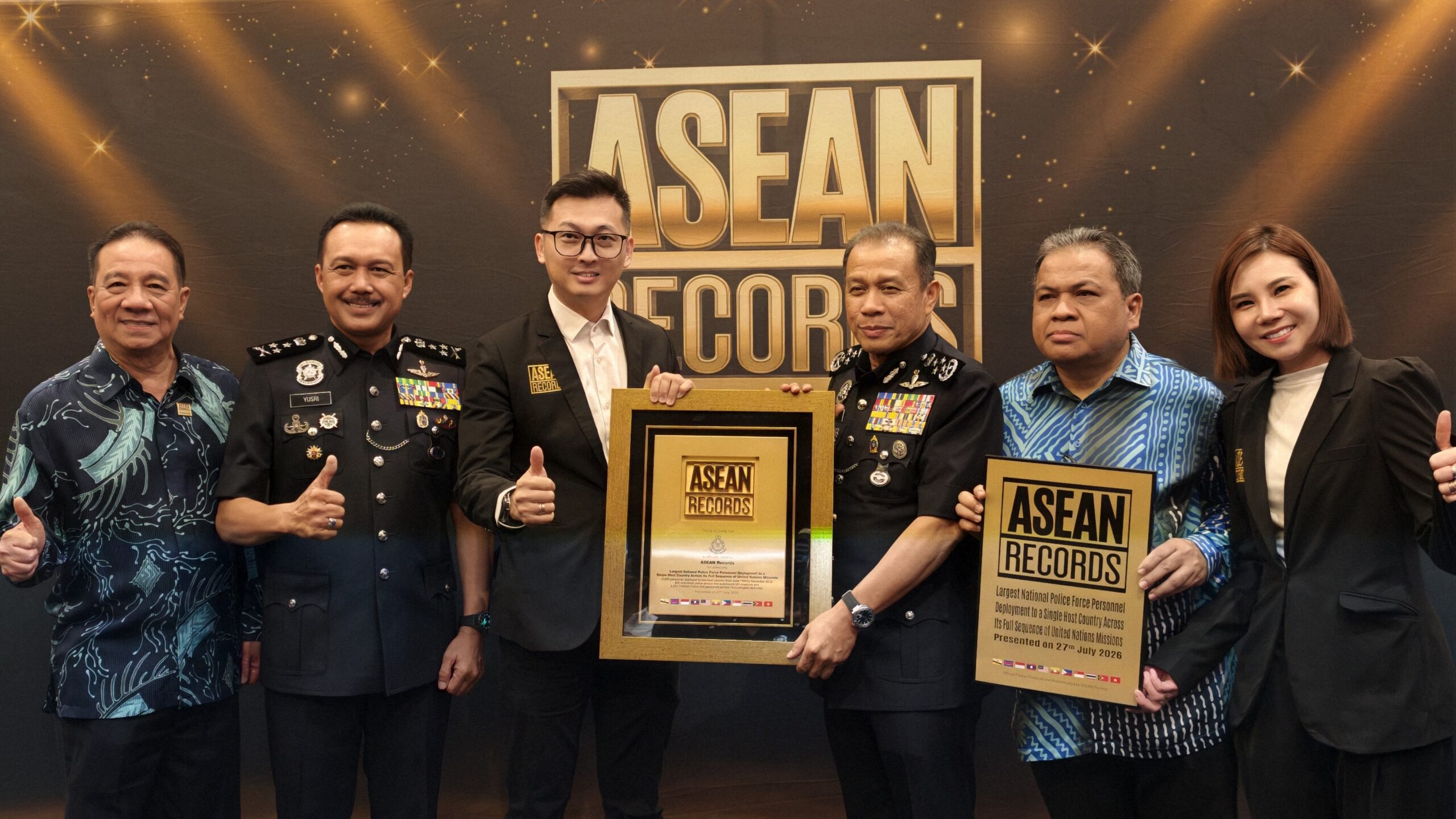 Six people pose with ASEAN Records awards at a ceremony, including two in military uniforms and others in formal attire.