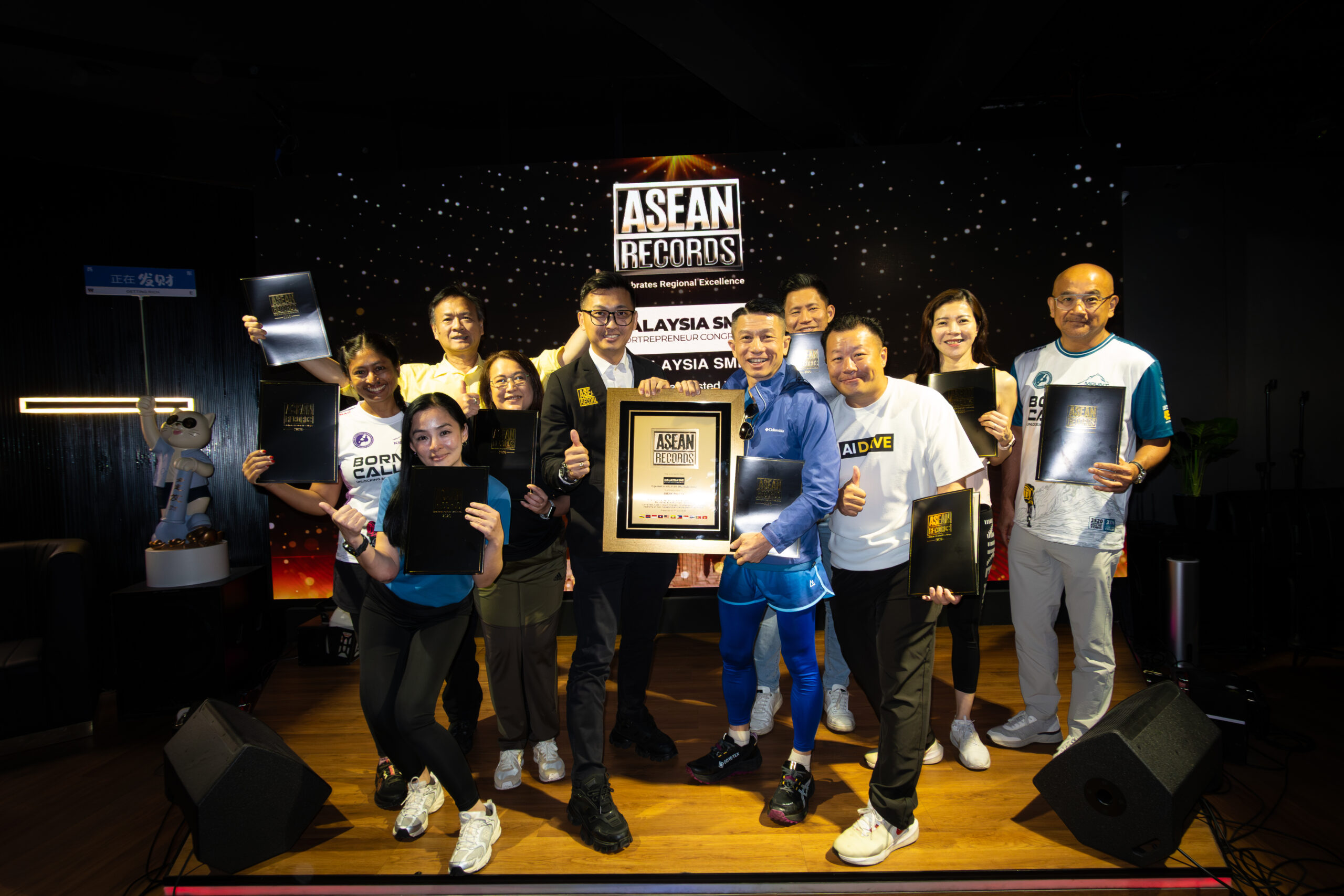 Group of people posing on stage with awards, ASEAN Records banner in the background.